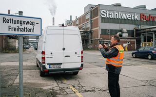 Ein weißer Sprinter steht auf einer Straße neben einem Schild mit der Aufschrift "Rettungsweg freihalten"
